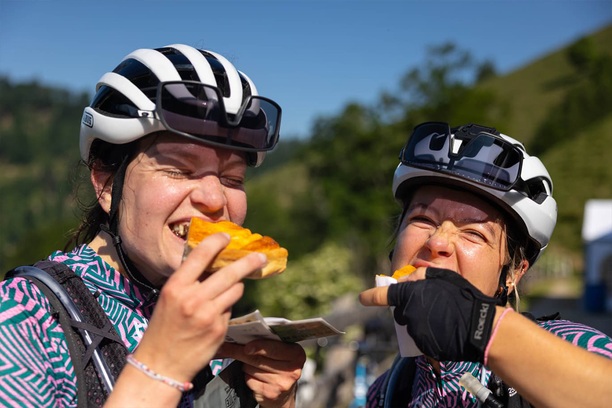 Two cyclist girls eating a cake